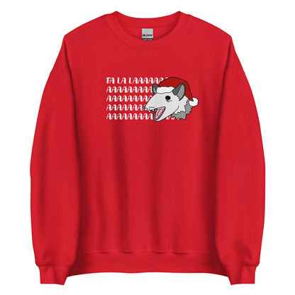 A red crewneck sweatshirt featuring an illustration of a possum wearing a Santa hat. The possum appears to be screaming, and text behind his head reads "FA LA LAAAAAA"