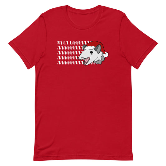 A red crewneck t-shirt featuring an illustration of a possum wearing a Santa hat. The possum appears to be screaming, and text behind his head reads "FA LA LAAAAAA"