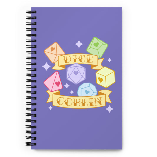 A purple wire-bound notebook featuring an illustration of multiple polyhedral dice surrounded by banners and sparkles. Text on the banner reads "Dice Goblin".