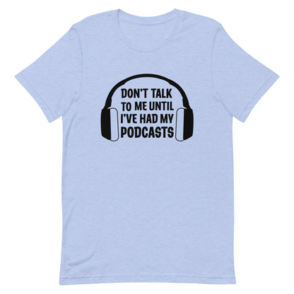 A heathered light blue crewneck t-shirt featuring an image of headphones surrounding text reading "Don't talk to me until I've had my podcasts"