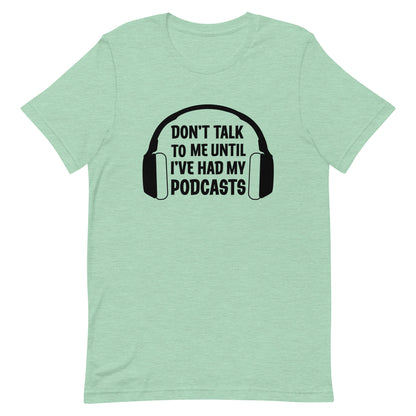 A heathered light green crewneck t-shirt featuring an image of headphones surrounding text reading "Don't talk to me until I've had my podcasts"
