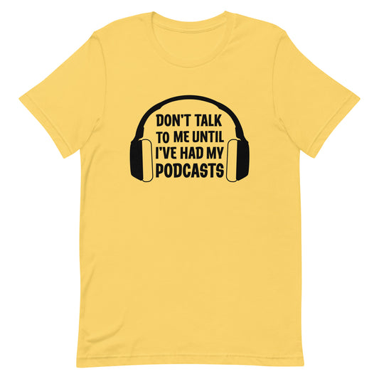 A yellow crewneck t-shirt featuring an image of headphones surrounding text reading "Don't talk to me until I've had my podcasts"