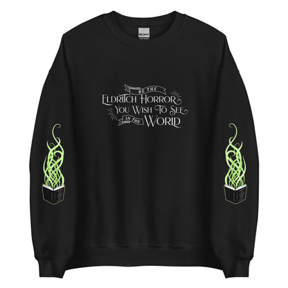 A black crewneck sweatshirt with white old-fashioned text on the chest that reads "Be The Eldritch Horror You Wish To See In The World". On each sleeve is an illustration of a spellbook with green magical tendrils spreading upward from the pages.