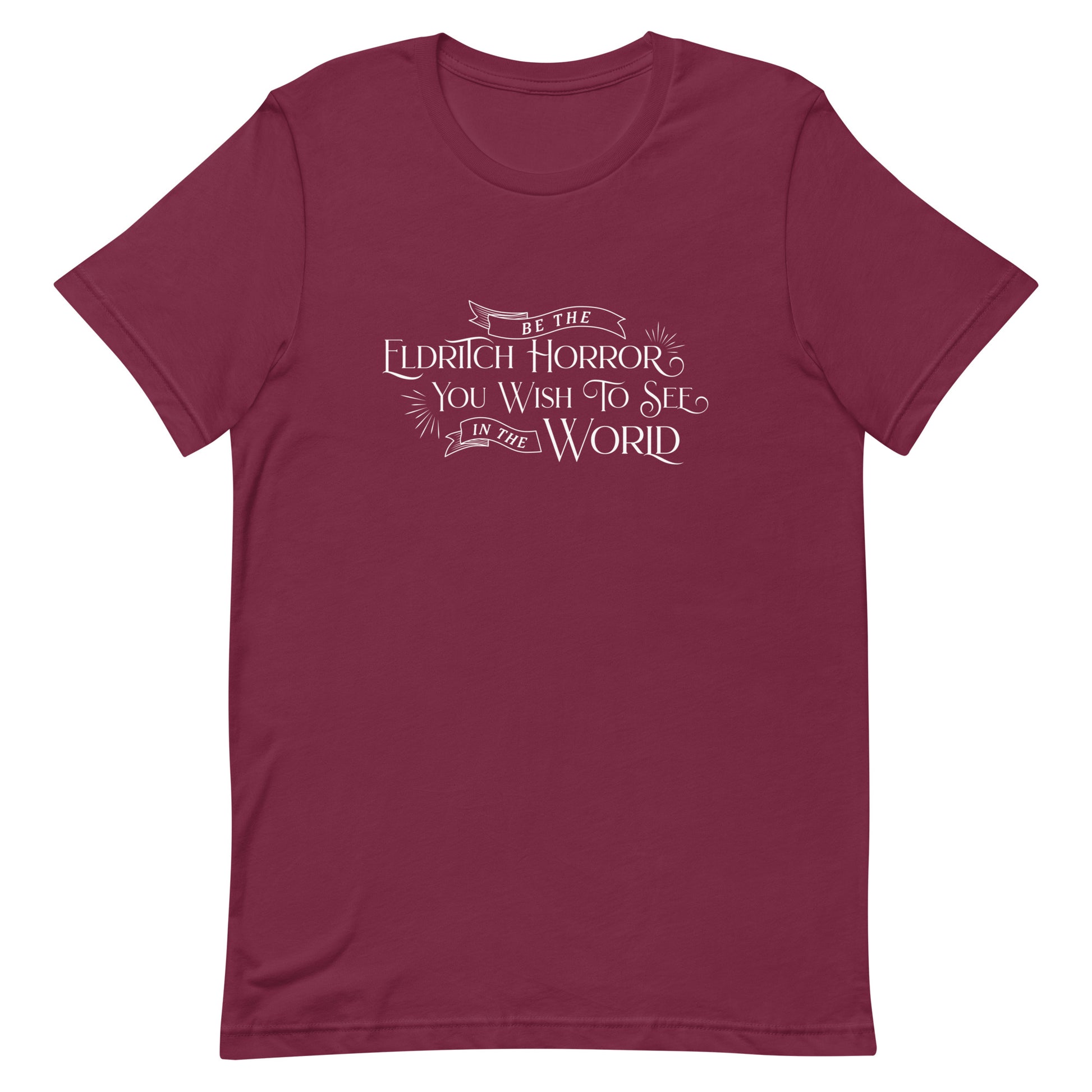 A maroon crewneck t-shirt with white text in an old-fashioned style that reads "Be The Eldritch Horror You Wish To See In The World"