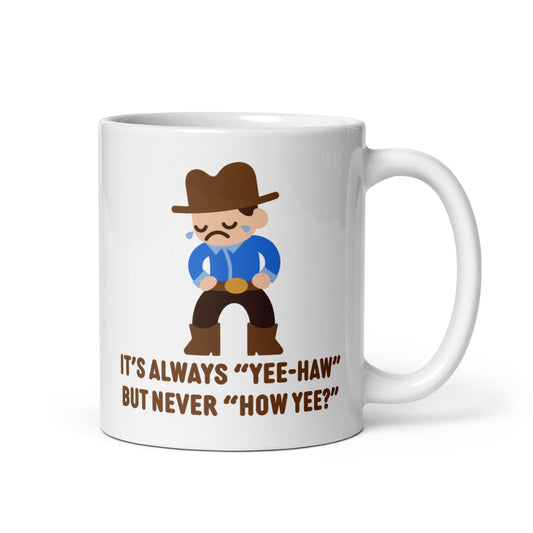A white, 11 ounce ceramic coffee mug featuring an illustration of a crying cowboy wearing a blue shirt. Text below the cowboy reads "It's always "yee-haw" but never "How yee?""
