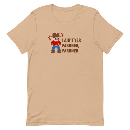 A tan crewneck t-shirt featuring an illustration of a grumpy cowboy wearing a red shirt. Text alongside the cowboy reads "I ain't yer pardner, pardner."