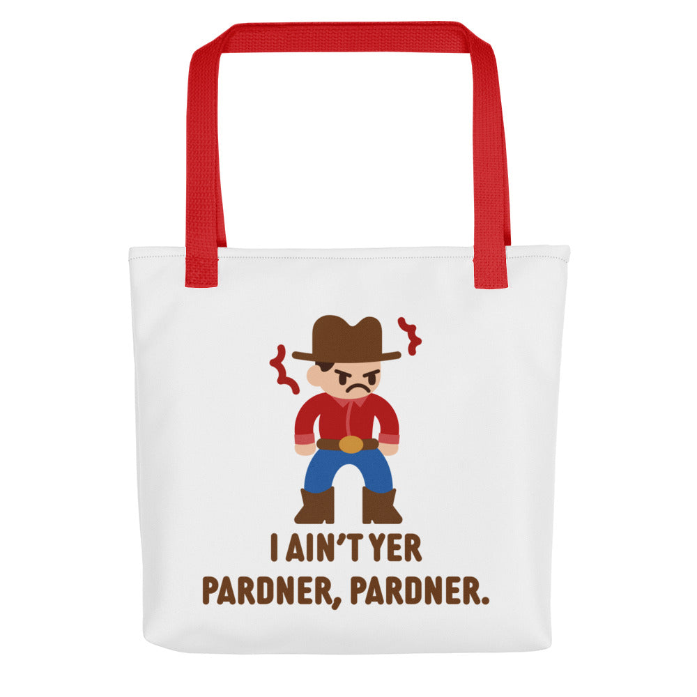 A white canvas tote bag with a red handle featuring an illustration of a grumpy cowboy wearing a red shirt. Text alongside the cowboy reads "I ain't yer pardner, pardner."