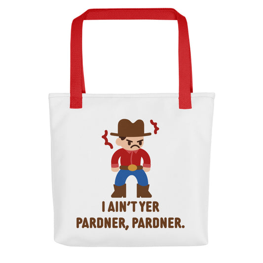 A white canvas tote bag with a red handle featuring an illustration of a grumpy cowboy wearing a red shirt. Text alongside the cowboy reads "I ain't yer pardner, pardner."