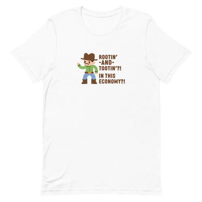 A white crewneck t-shirt featuring an illustration of a confused-looking cowboy wearing a green shirt. Text to the right of the cowboy reads "Rootin' AND tootin'?! In this economy?!"