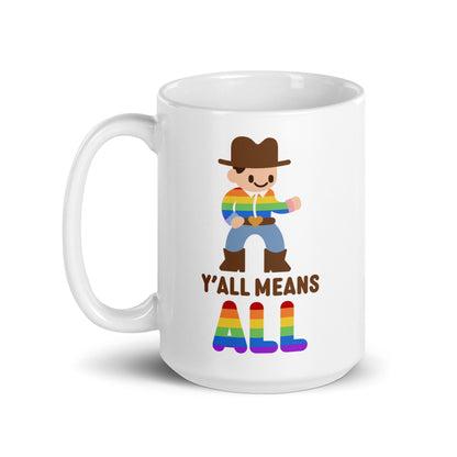 A white 15 ounce coffee mug featuring an illustration of a smiling cowboy wearing a rainbow striped shirt. Text underneath the cowboy reads "Y'all means ALL". The word "ALL" is rainbow-colored to match the cowboy's shirt.