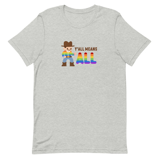A grey crewneck t-shirt featuring an illustration of a smiling cowboy wearing a rainbow striped shirt. Text alongside the cowboy reads "Y'all means ALL". The word "ALL" is rainbow-colored to match the cowboy's shirt.