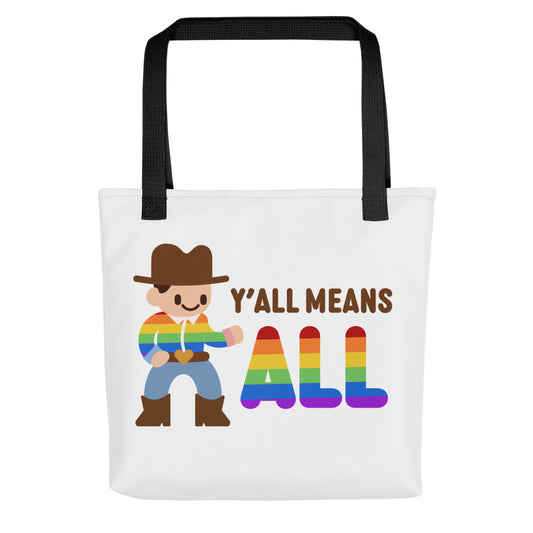 A white canvas tote bag with black handles featuring an illustration of a smiling cowboy wearing a rainbow striped shirt. Text alongside the cowboy reads "Y'all means ALL". The word "ALL" is rainbow-colored to match the cowboy's shirt.