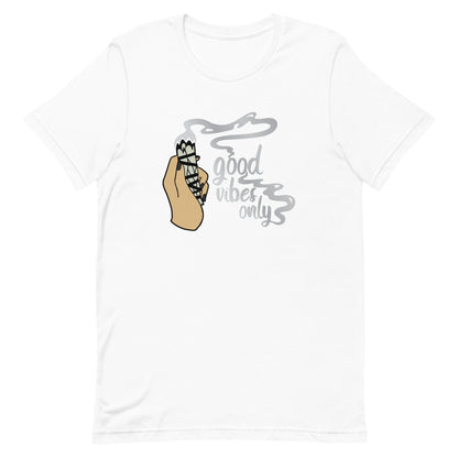 A white crewneck t-shirt featuring an illustration of a hand holding a sage smudge stick. Smoke is flowing from the tip of the sage and forms text reading "good vibes only"