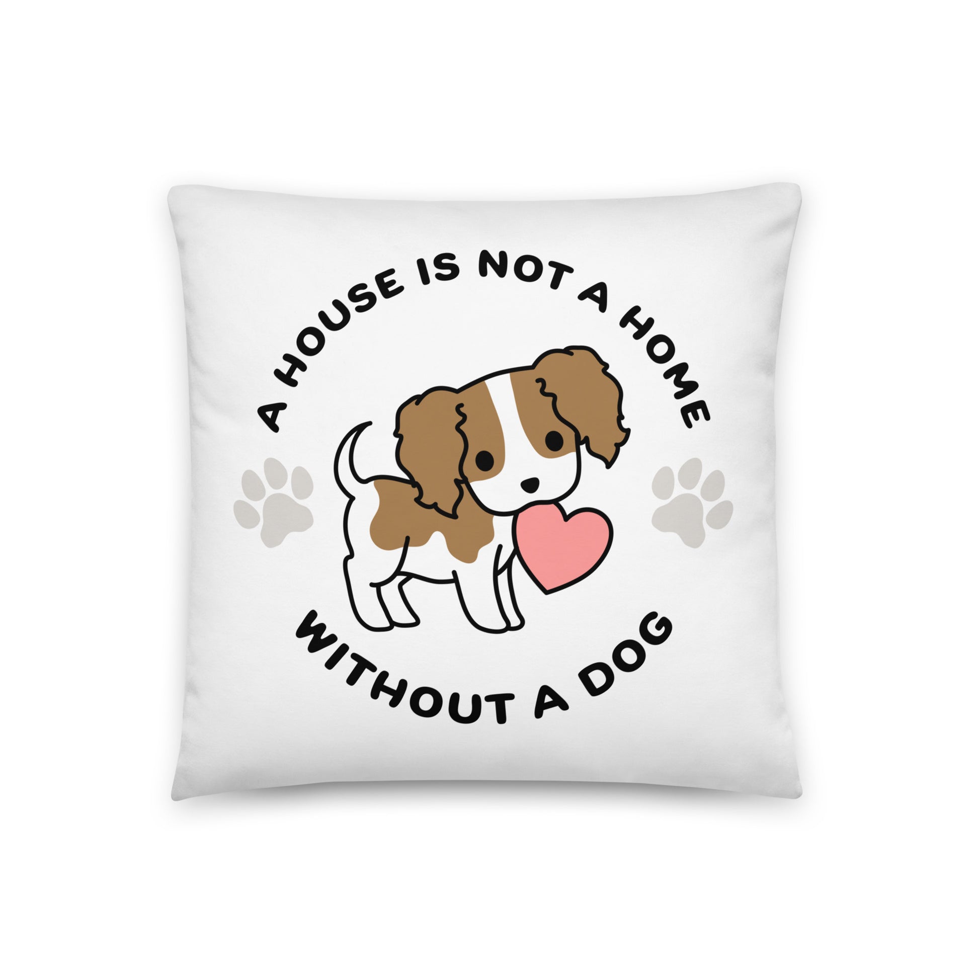 A white, 18" x 18" pillow featuing a cute, stylized illustration of a Cavalier King Charles Spaniel holding a heart in its mouth. Text in a circle around the dog reads "A house is not a home without a dog"