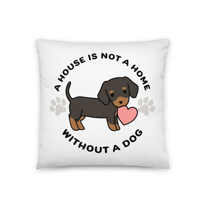 A white, 18" x 18" pillow featuing a cute, stylized illustration of a Dachschund holding a heart in its mouth. Text in a circle around the dog reads "A house is not a home without a dog"