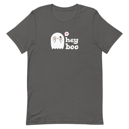 A medium grey crewneck t-shirt featuring an image of a cute smiling and blushing ghost. Text alongside the ghost reads "hey boo"
