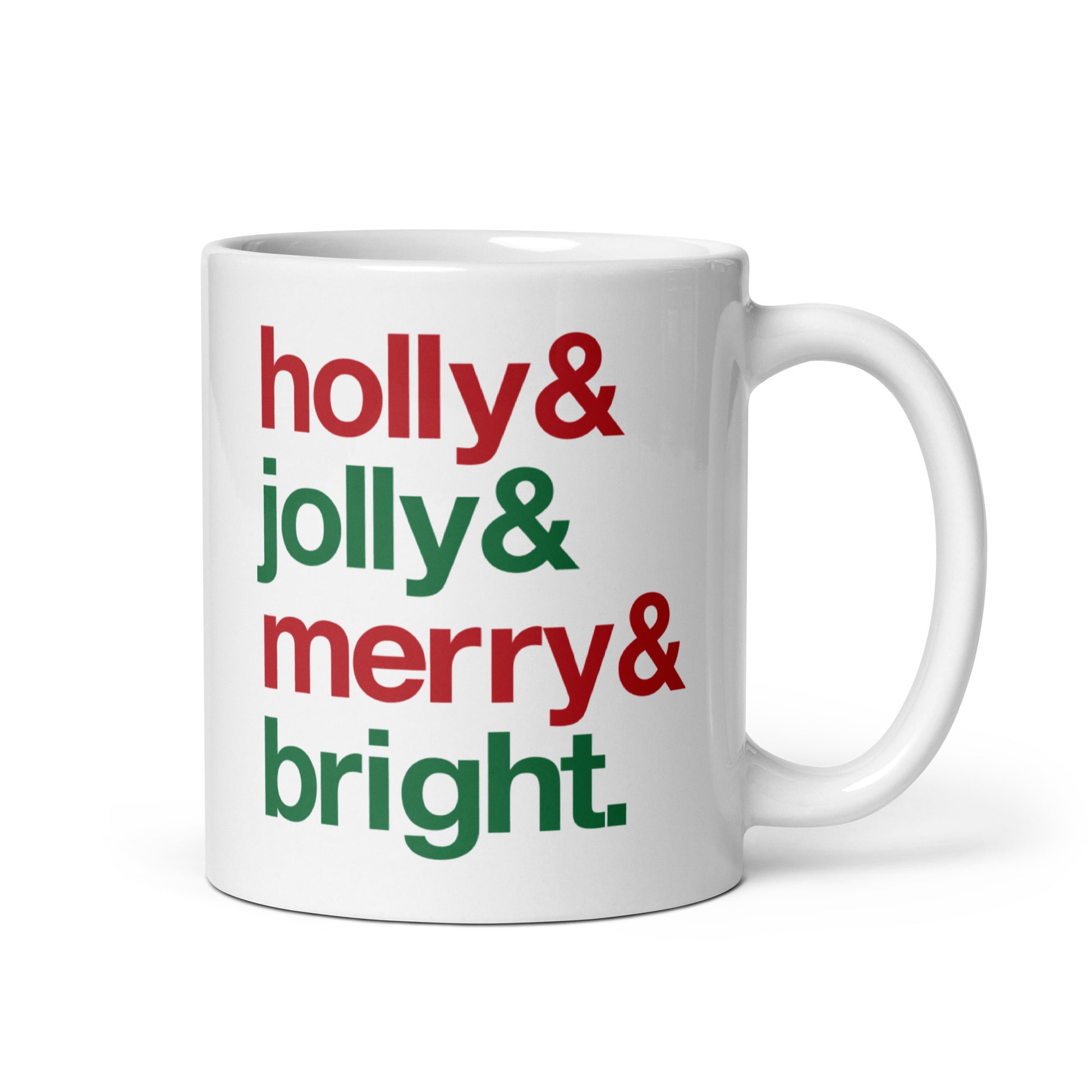 A white 11 ounce ceramic mug with four lines of red and green text that read "Holly & Jolly & Merry & Bright"