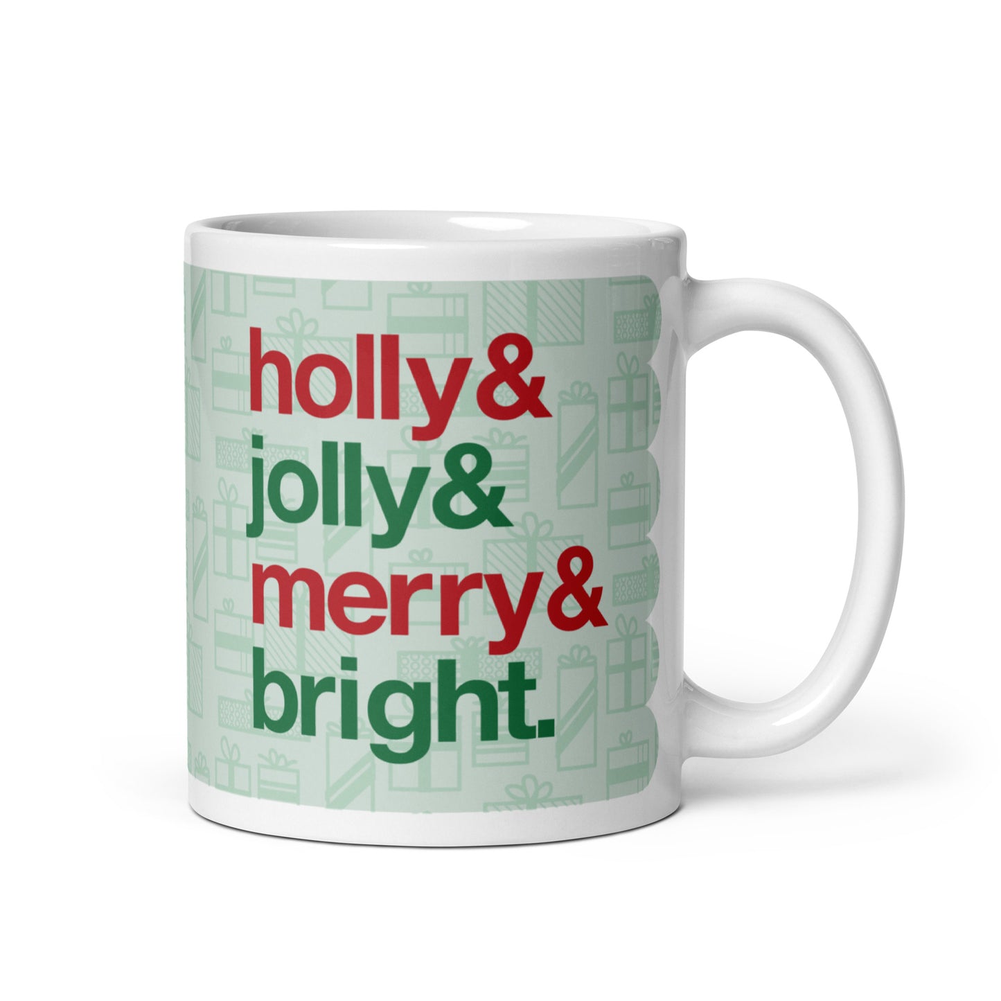 An 11 ounce ceramic mug with four lines of red and green text on a background pattern of light green presents of various sizes. The text on the mug reads "Holly & Jolly & Merry & Bright".