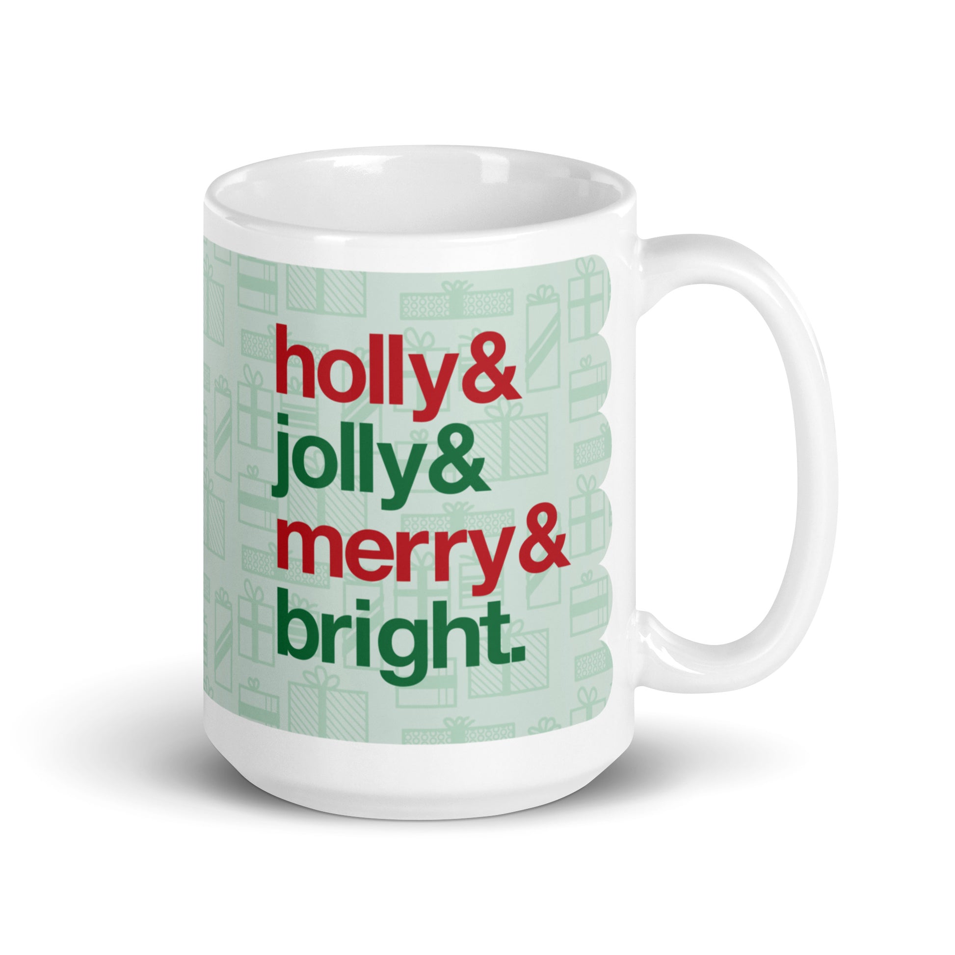 A 15ounce ceramic mug with four lines of red and green text on a background pattern of light green presents of various sizes. The text on the mug reads "Holly & Jolly & Merry & Bright".
