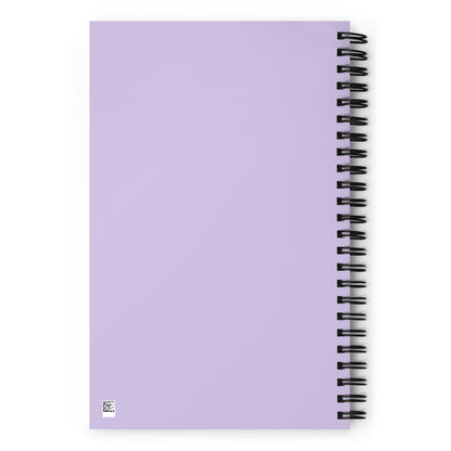 The blank back side of a light purple wire-bound notebook