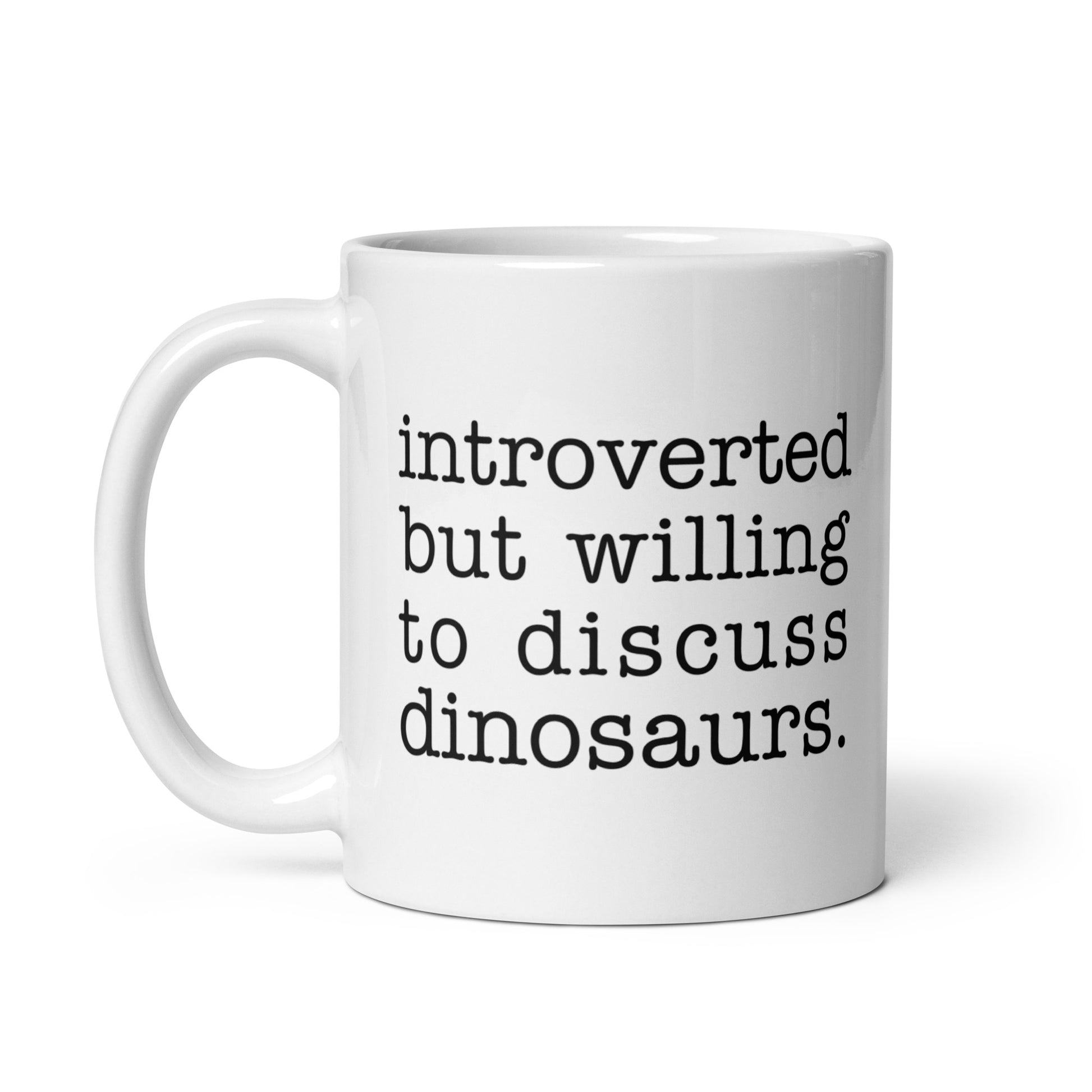A white 11 ounce ceramic mug with text reading "introverted but willing to discuss dinosaurs"