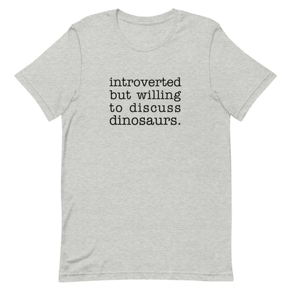 A medium gray crewneck t-shirt with black text reading "introverted but willing to discuss dinosaurs"