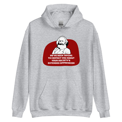 A grey hooded sweatshirt featuring a black and white illustration of Karl Marx wearing a telemarketer headset. Text beneath Marx reads "We've been trying to contact you about your society's extended oppression." in a blocky font.