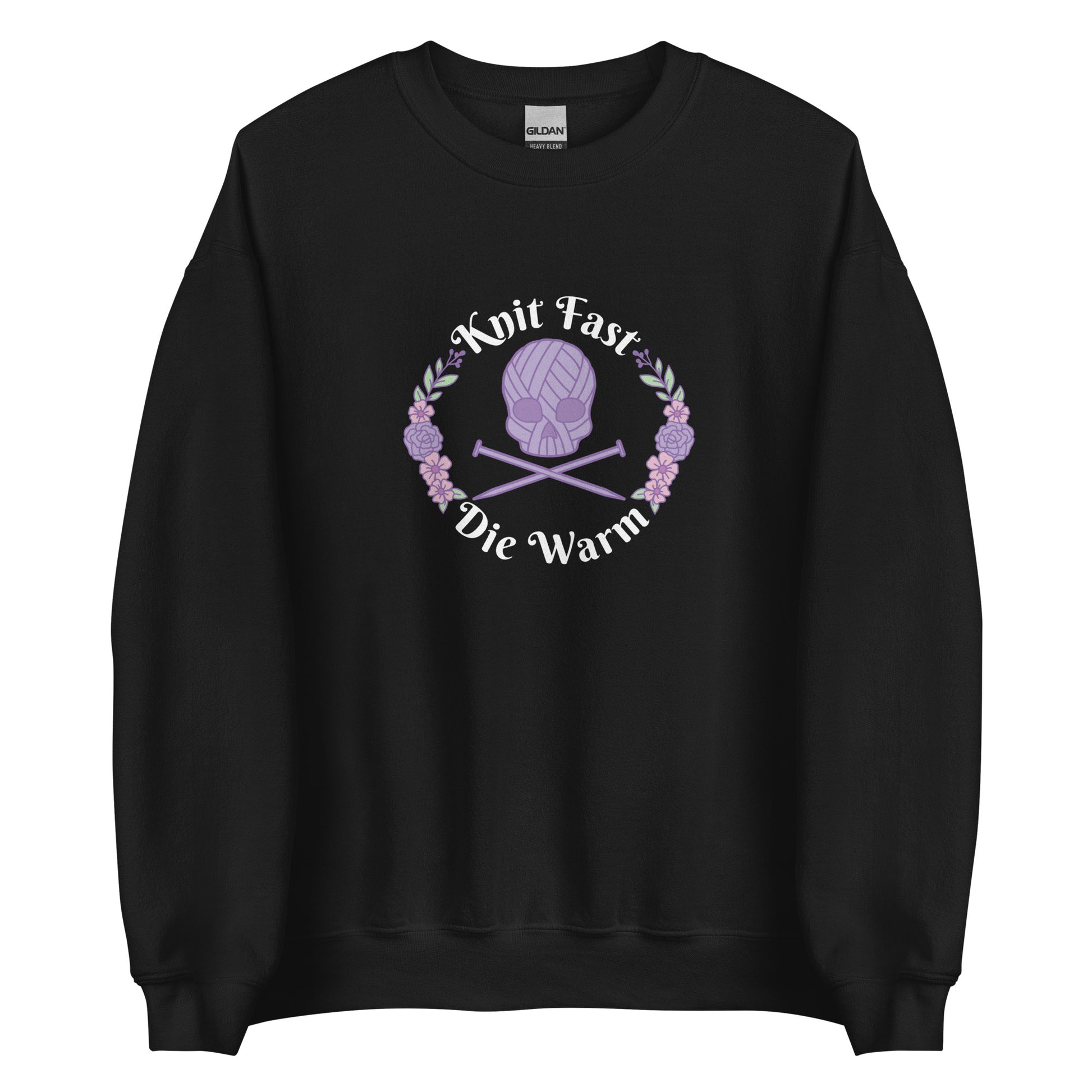 A black crewneck sweatshirt featuring an image of a skull and crossbones made of yarn and knitting needles. A floral wreath surrounds the skull, along with words that read "Knit Fast, Die Warm"