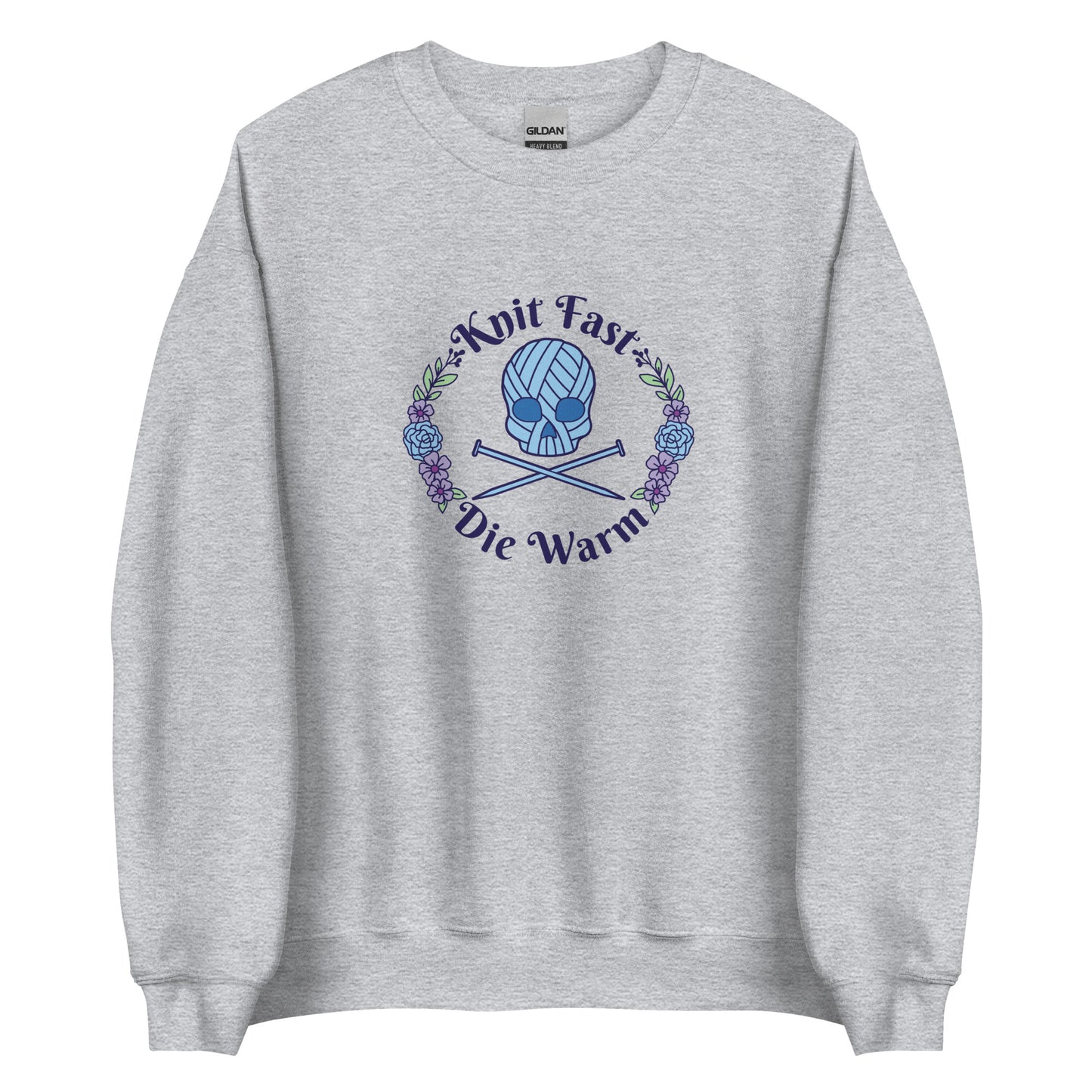 A gray crewneck sweatshirt featuring an image of a skull and crossbones made of yarn and knitting needles. A floral wreath surrounds the skull, along with words that read "Knit Fast, Die Warm"
