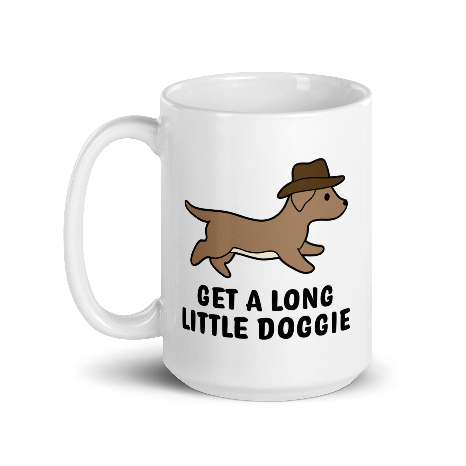 A white 15 ounce ceramic mug featuring an image of a dachshund wearing a cowboy hat. Text below the dog reads "Get a long little doggie"