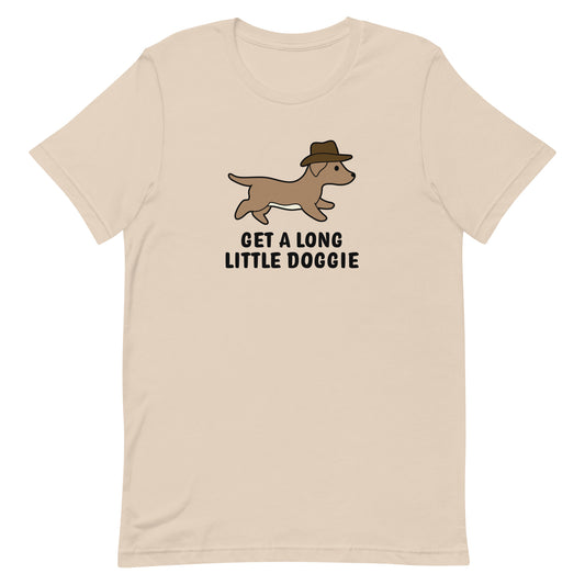 A cream-colored crewneck t-shirt featuring an image of a dachshund wearing a cowboy hat. Text below the dog reads "Get a long little doggie"