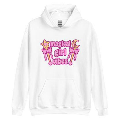 A white hooded sweatshirt featuring two gold wands with pink bows and pink text reading "Magical girl vibes"