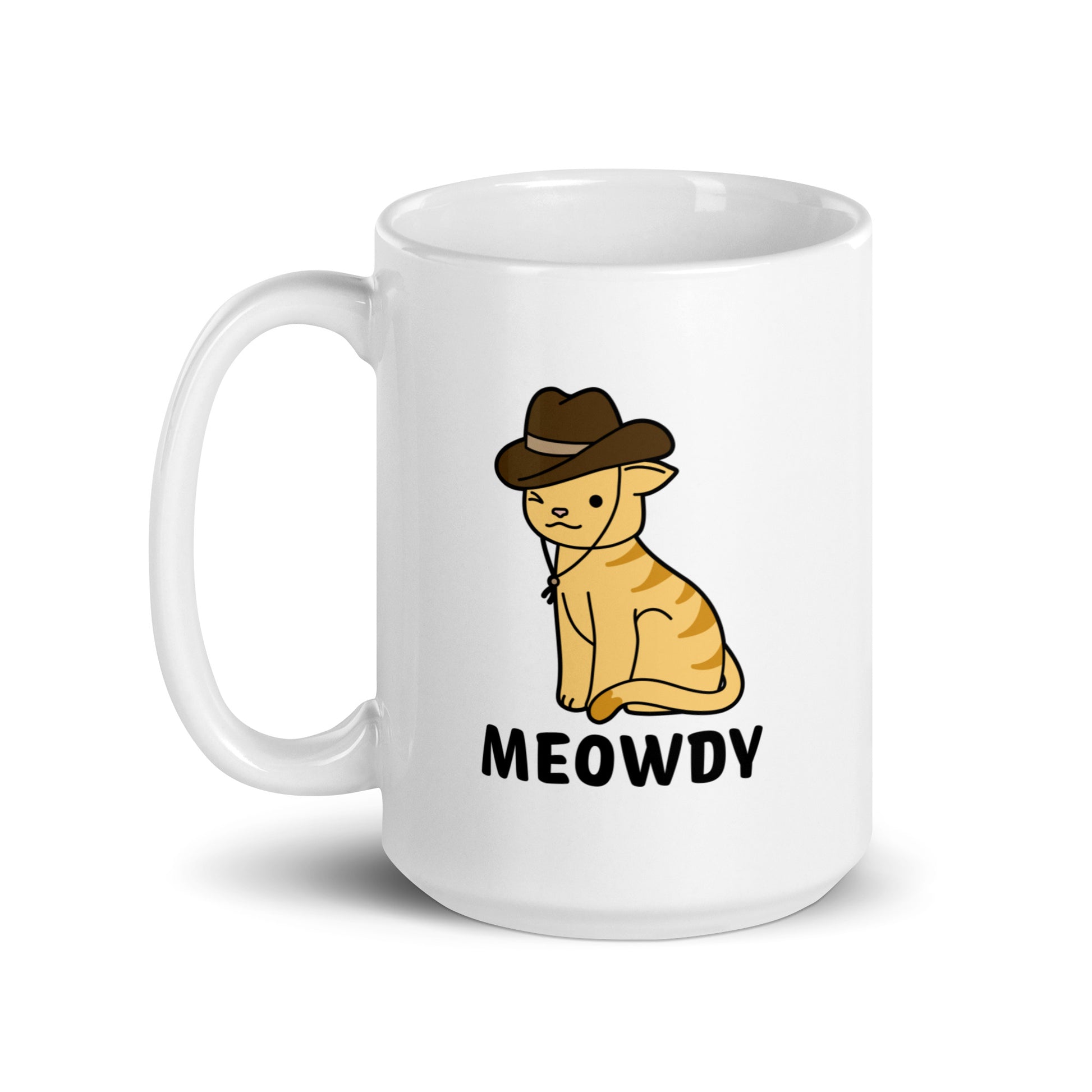 A white, 15 ounce ceramic coffee mug featuring an illustration of an orange striped cat wearing a cowboy hat. The cat is winking and smiling, and text beneath him reads "Meowdy"
