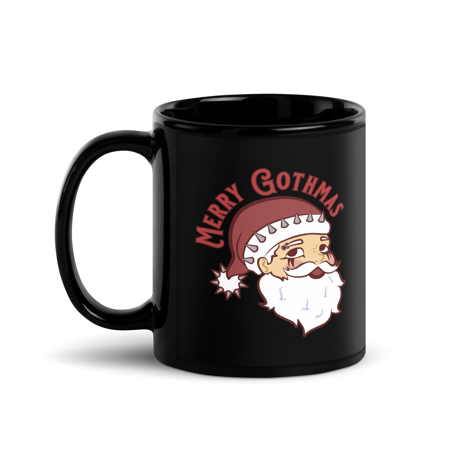 A black ceramic coffee mug featuring an image of Santa Claus. Santa's hat has spikes on it and he is wearing goth-style makeup. Text above Santa's head reads "Merry Gothmas"