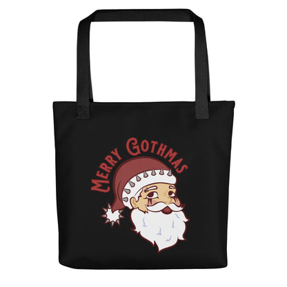 A black tote bag with black handles featuring an image of Santa Claus. Santa is wearing goth-style makeup and his hat is decorated with spikes. Text above Santa's head reads "Merry Gothmas"