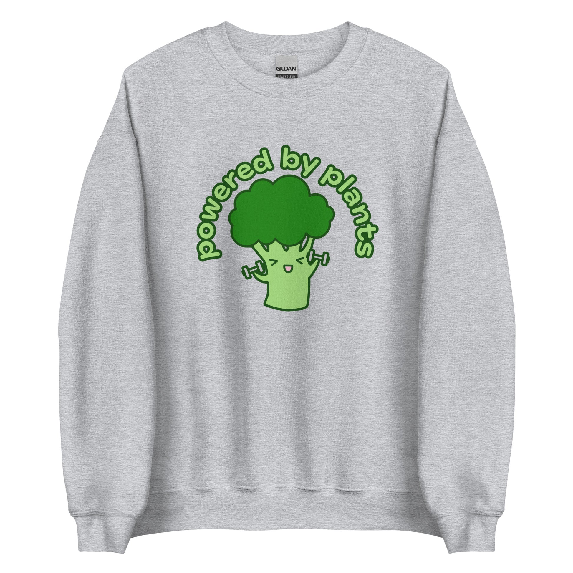 A grey crewneck sweatshirt featuring an illustration of a cartoon broccoli character. The broccoli is excitedly lifting weights, and text in an arc above the broccoli reads "powered by plants".