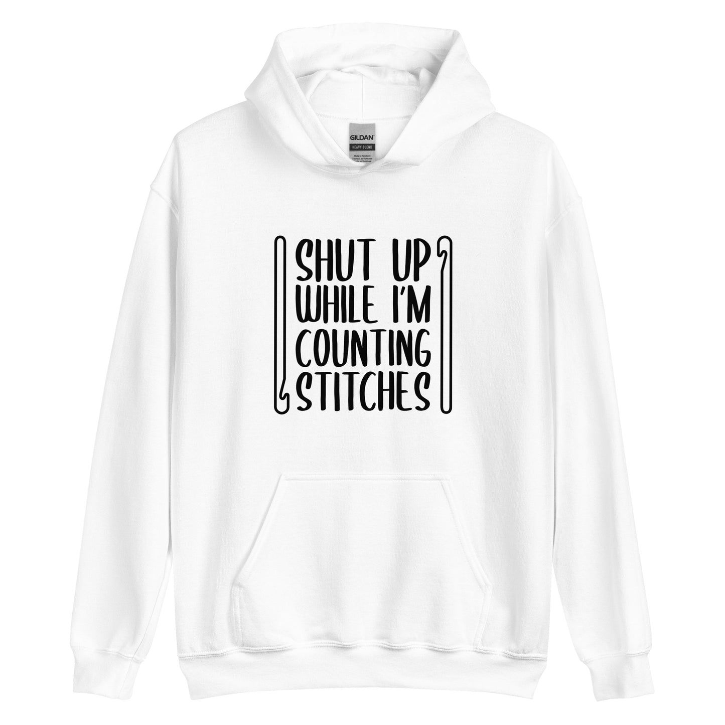A white hooded sweatshirt featuring black text that reads "Shut up while I'm counting stitches." The text is framed by a crochet hook to the left and right.