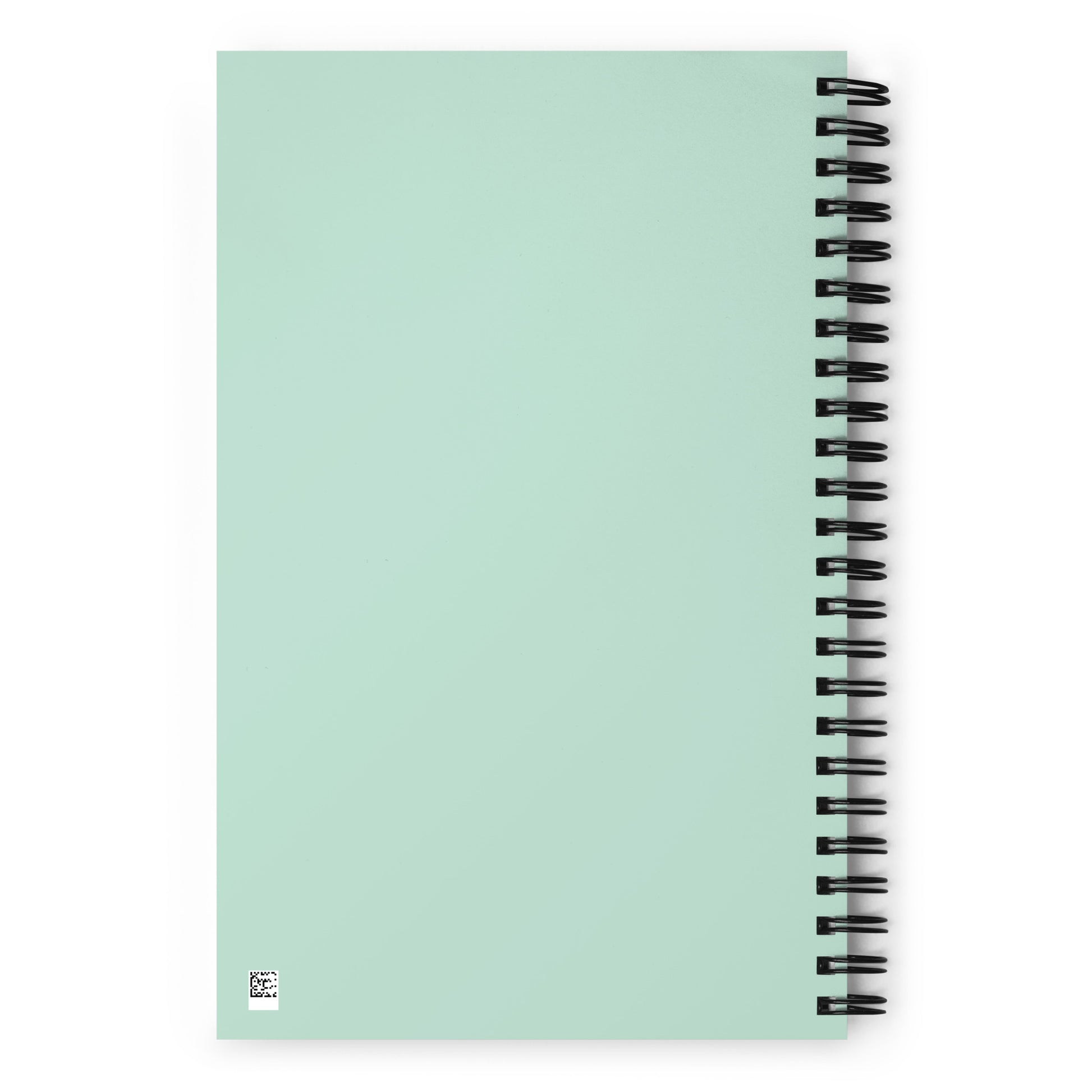 The back side of a light mint green wirebound notebook.