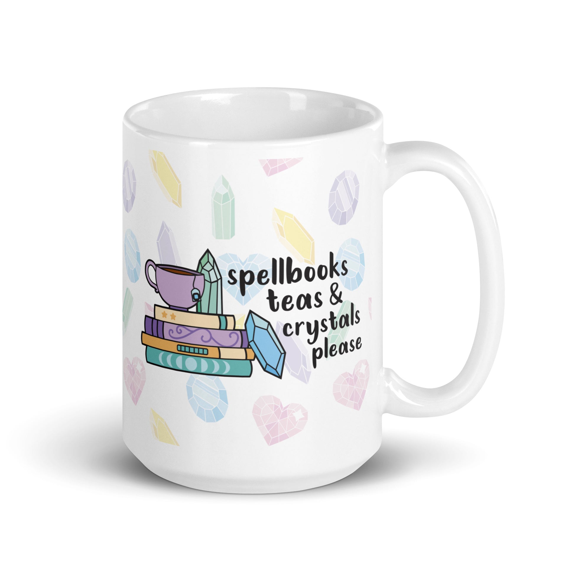 A white 15 ounce ceramic mug with a pattern of pastel crystals. In the center of the mug is an illustration of several books and crystals and a teacup. Text along side the image reads "Spellbooks, teas, & crystals please"