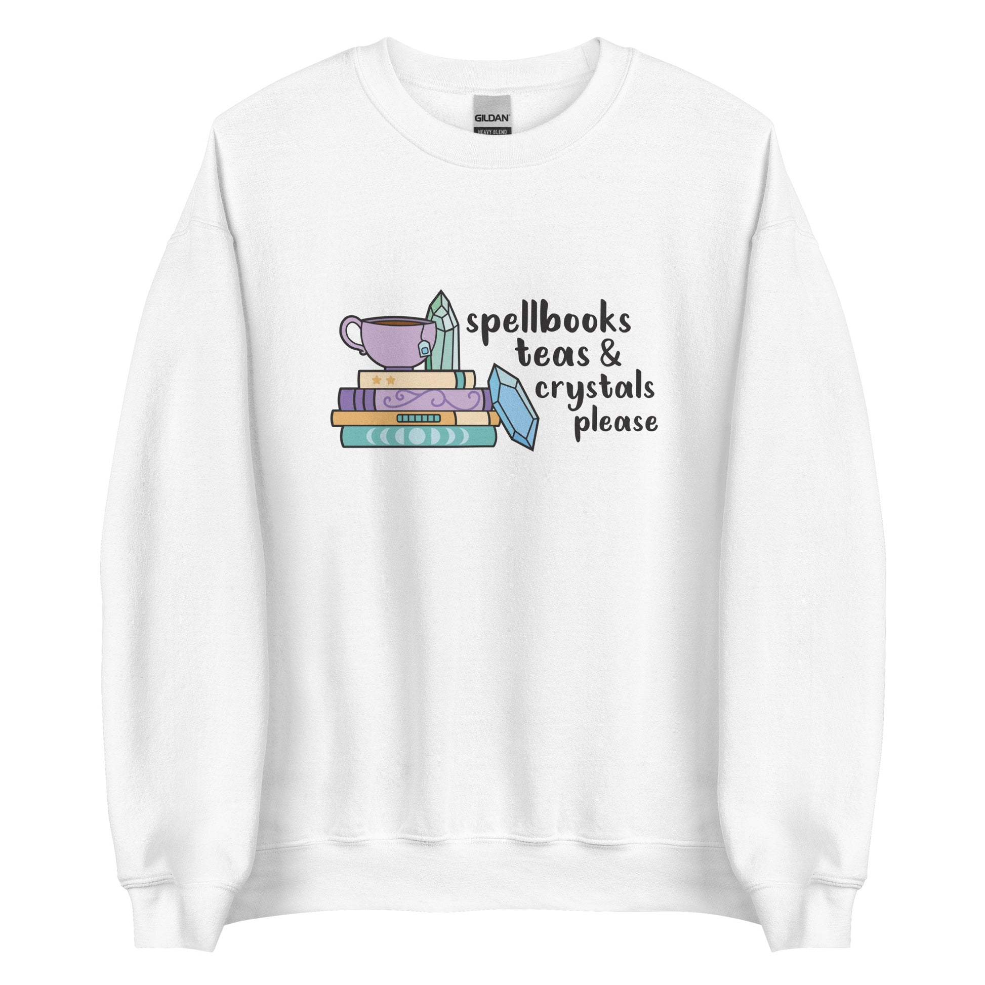 A white crewneck sweatshirt featuring an illustration of a stack of spellbooks with a teacup and a crystal resting on top. Another crystal rests on the side of the stack, and text next to the illustration reads "Spellbooks, teas & crystals please"