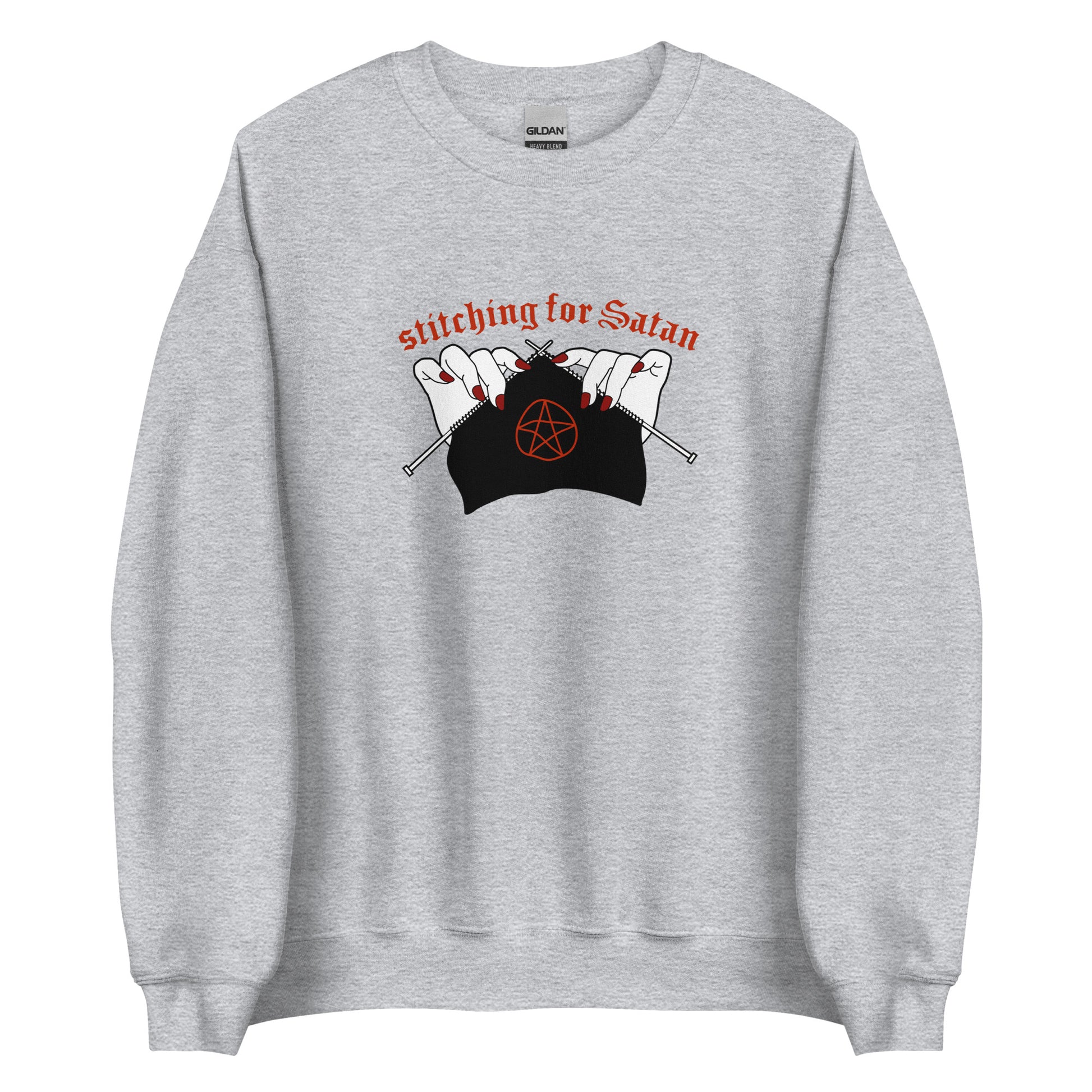 A grey crewneck sweatshirt featuring an illustration of pale white hands with red fingernails holding knitting needles. Fabric on the needles features a red pentagram. Text above the hands reads "stitching for Satan" in a gothc red font.