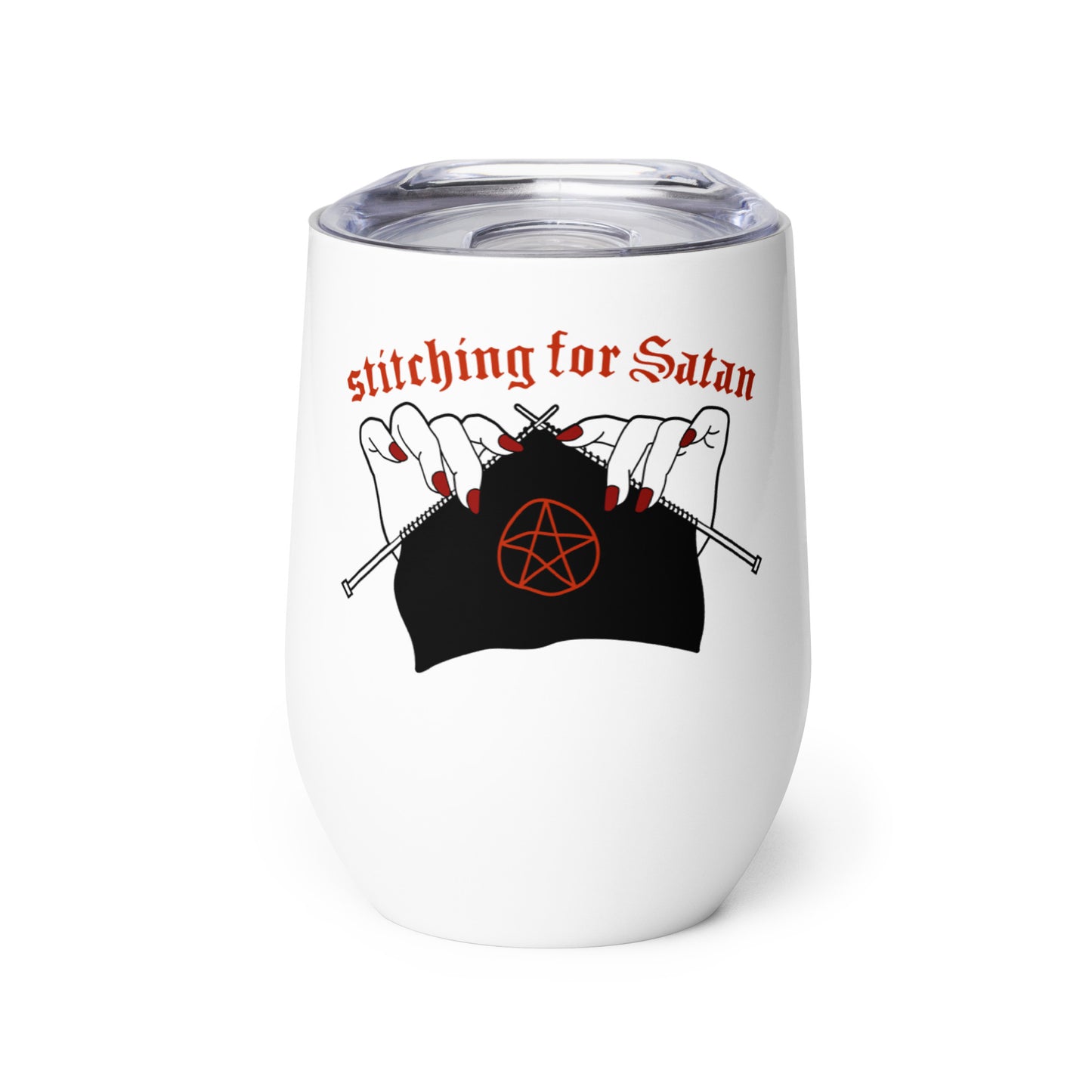 A white 12 ounce wine tumbler with a clear plastic lid. The tumbler is decorated with an illustration of pale white hands with painted red nails holding knitting needles. Black fabric on the needles features a red pentagram, and text above the hands reads "stitching for Satan" in a gothic red font.