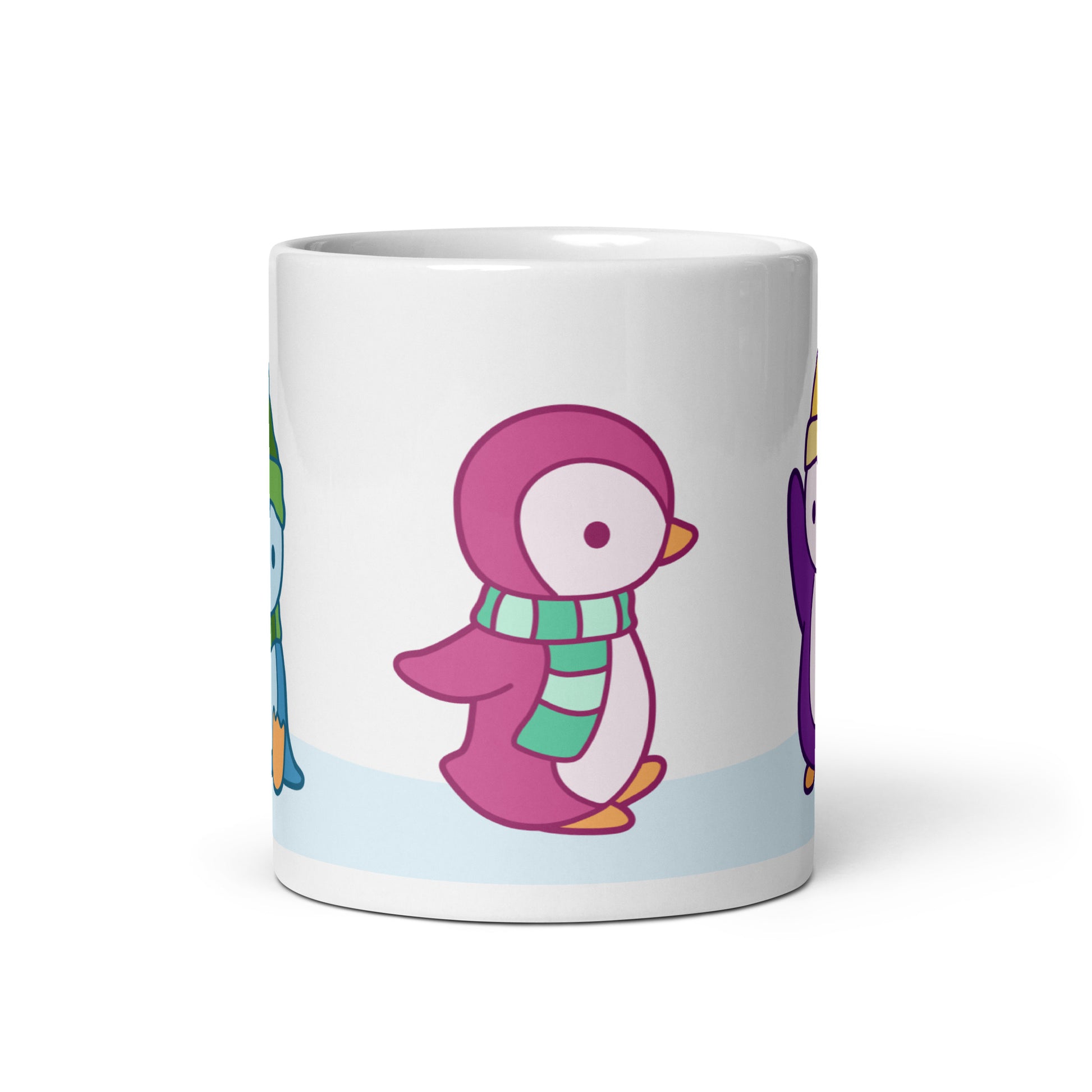 A white 11 ounce ceramic mug featuring an illustration of peguins in the snow. The primary visible penguin is pink, with a green striped scarf.