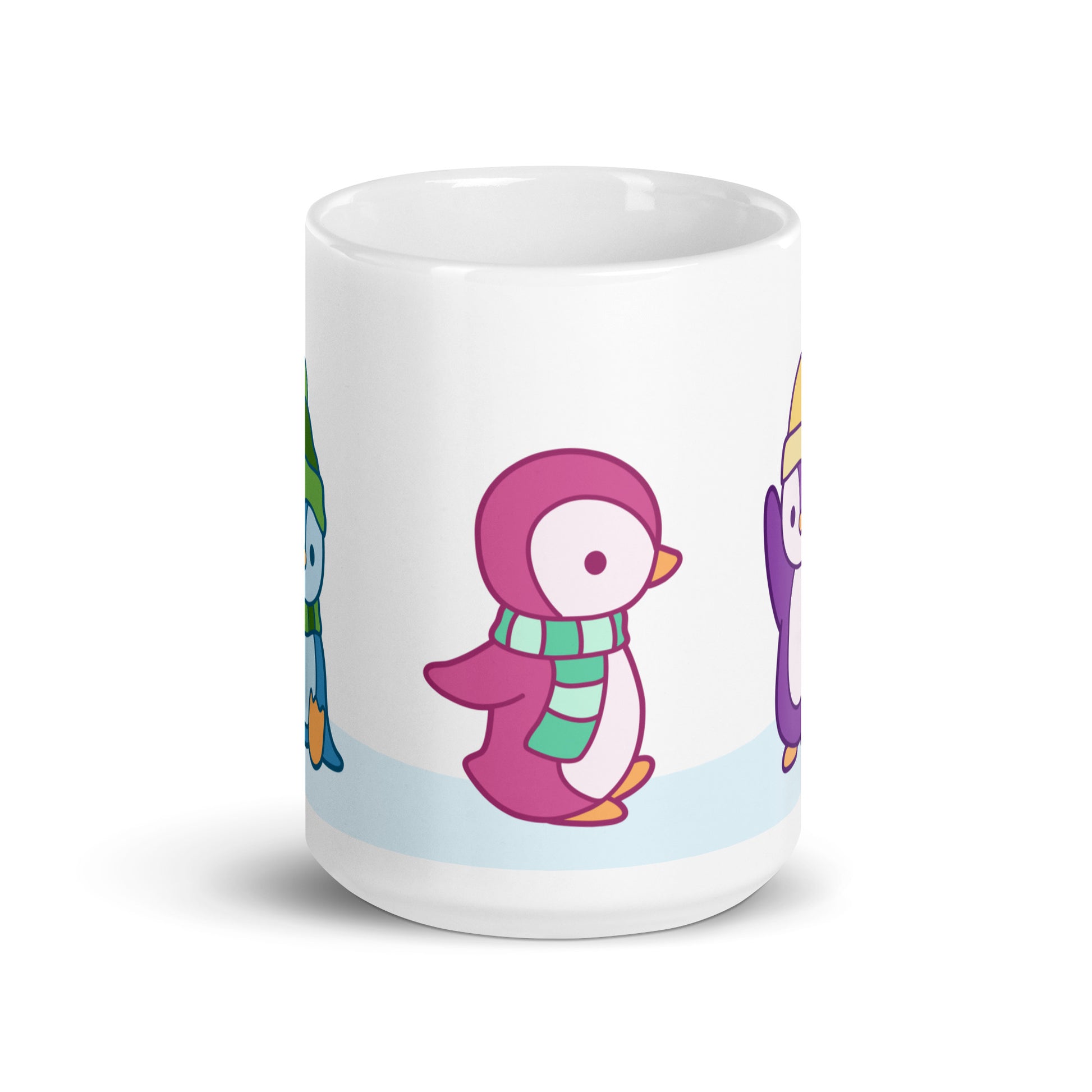 A white 15 ounce ceramic mug featuring an illustration of peguins in the snow. The primary visible penguin is pink, with a striped green scarf.