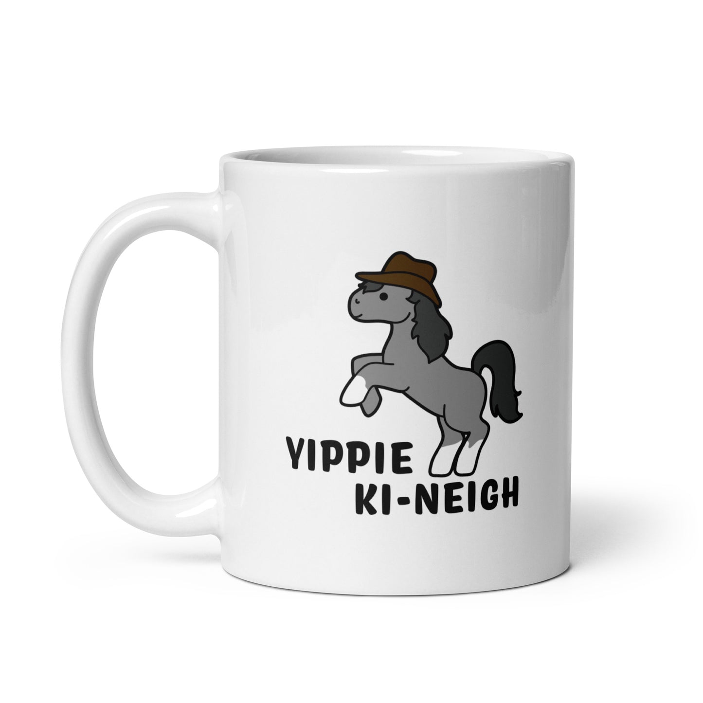 A white 11 ounce ceramic coffee mug featuring an illustration of a smiling grey pony rearing and wearing a cowboy hat. Text underneath the pony reads "Yippie Ki-Neigh"
